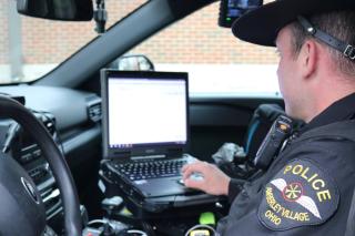 Patrol Officer reviews in-car computer